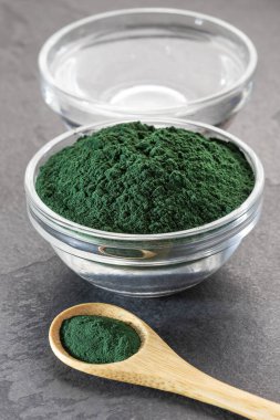 Organik spirulina tozu ve filtrelenmiş su dolu kaşık.