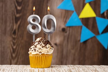 yanan mum - 80 numaralı doğum günü arkaplanda flama ile