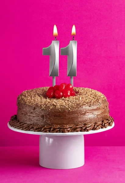 11キャンドル ピンクの背景にチョコレートケーキ — ストック写真