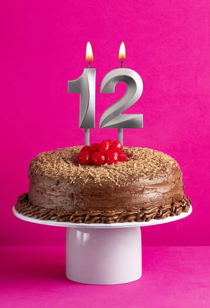 Birthday card with candle number 12 - Chocolate cake on pink background