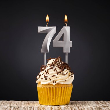 74 numaralı mumlu doğum günü pastası - Karanlık arka planda kutlama