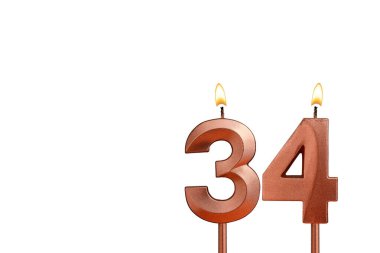 Doğum günü için beyaz arkaplanda 34 numaralı mum yanıyor.