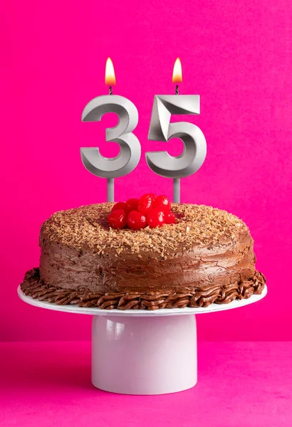 stock image Number 35 candle - Chocolate cake on pink background