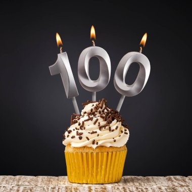 100 numaralı mumlu doğum günü keki. Koyu arkaplanda kutlama.