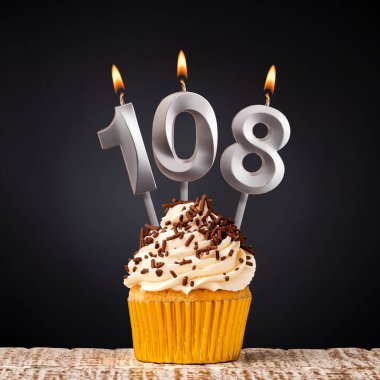 108 numaralı mumlu doğum günü pastası - Karanlık arka planda kutlama