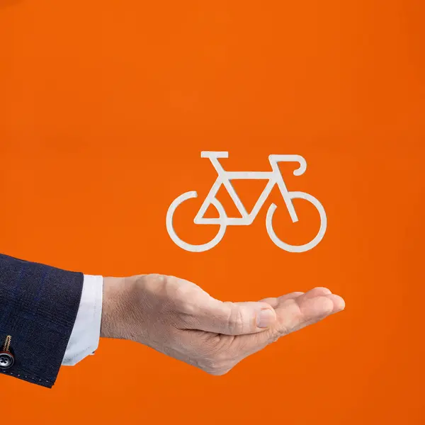 Businessman hand holding bicycle icon - Insurance policy - Businessman helps the environment by riding a bicycle