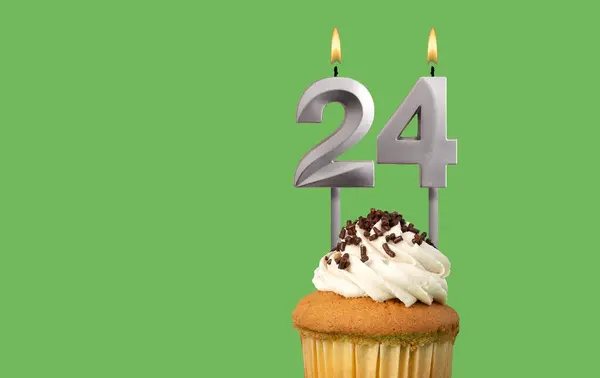 Birthday with number 24 candle and cupcake - Anniversary card on green color background