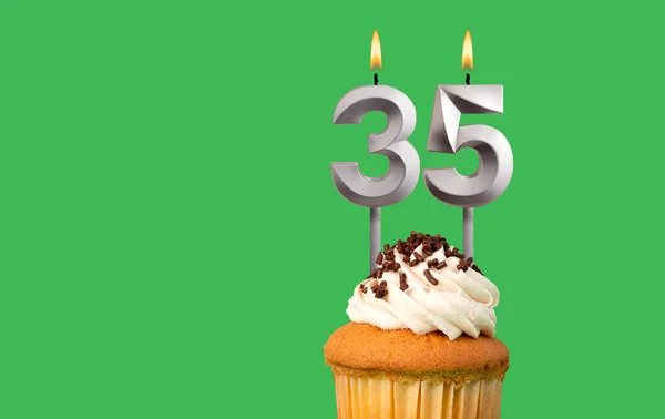 stock image Birthday card with candle number 35 - Cupcake on green background