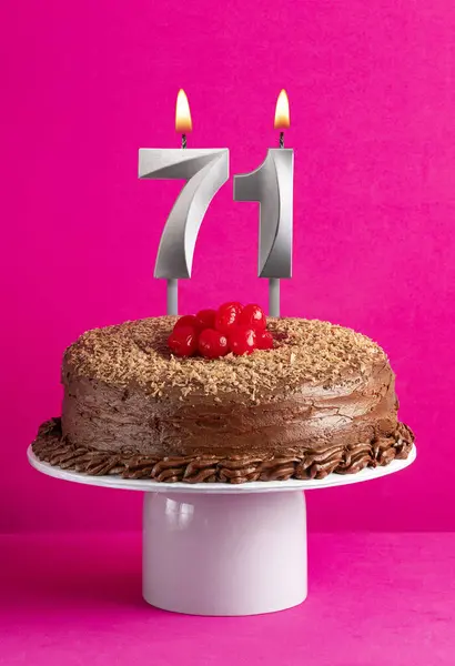 Number 71 candle - Chocolate cake on pink background