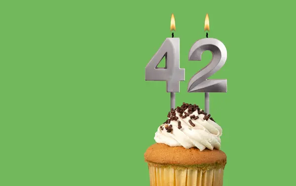 Birthday with number 42 candle and cupcake - Anniversary card on green color background