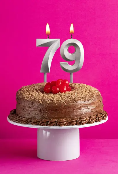 stock image Number 79 candle - Chocolate cake on pink background