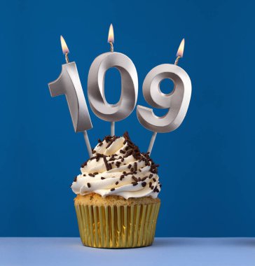 109 numaralı yanan mum - Mavi arka planda pastayla birlikte doğum günü kartı