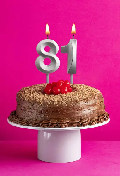 Number 81 candle - Chocolate cake on pink background