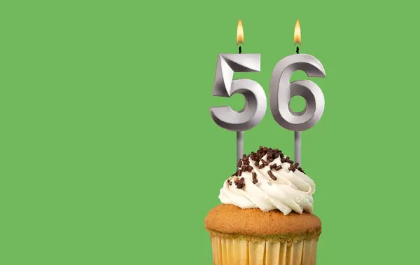 stock image Birthday with number 56 candle and cupcake - Anniversary card on green color background