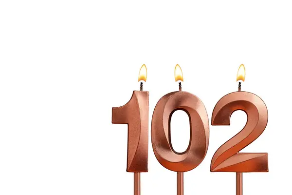 Burning candle number 102 for birthday on white background