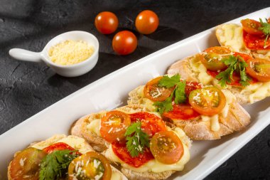 Başlangıç ya da antipasto - Fransız ekmeğine dilimlenmiş İspanyol sosisi ve vişneli domates ve mozzarella peyniri.