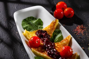 Kızarmış papialpa peyniri, kırmızı meyve reçeli, kiraz domates ve fesleğen.