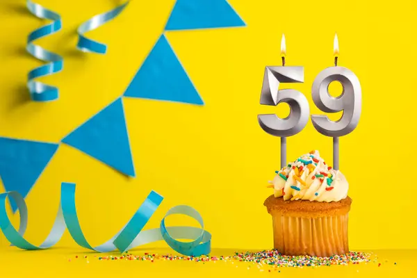 stock image Birthday candle number 59 with cupcake - Yellow background with blue pennants