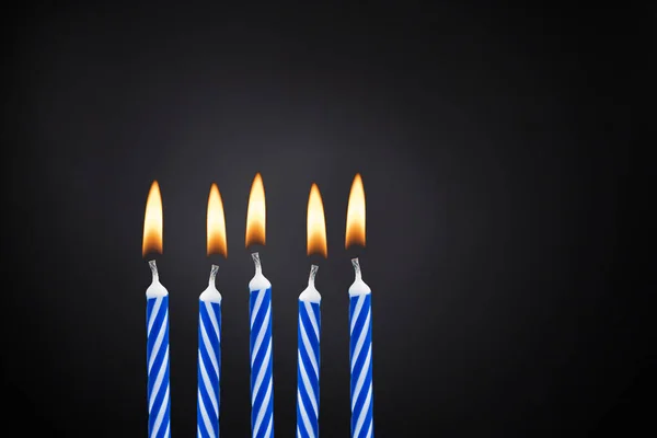 5 blue birthday candles on black background