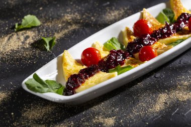 Kızarmış papialpa peyniri, kırmızı meyve reçeli, kiraz domates ve fesleğen.