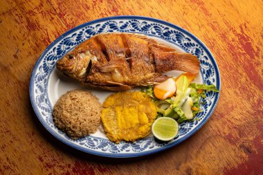 Hindistancevizi pilavlı tilapia balığı, mantar ve sebze salatası.