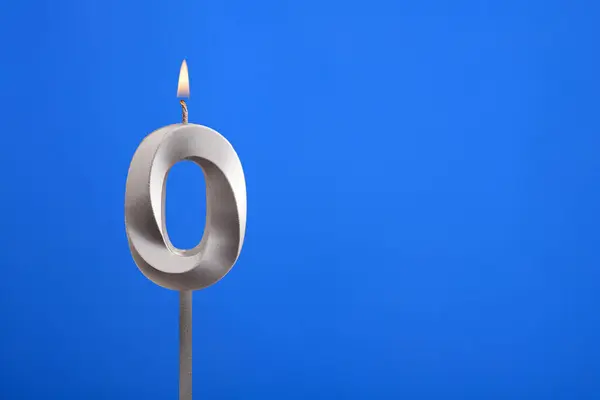 Birthday number 0 - Candle lit on blue background