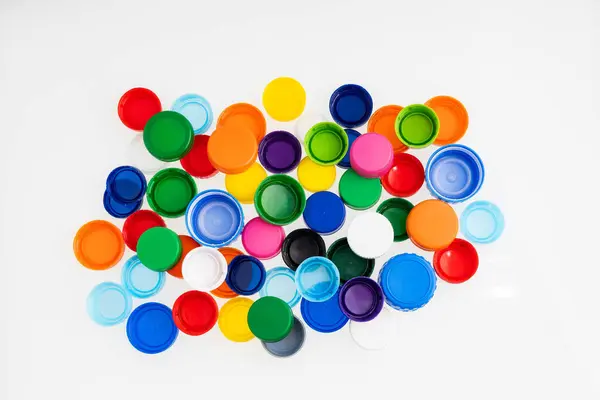Plastic bottle caps of different colors for recycling - White background