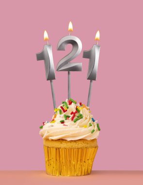 İçinde kek ve mum numarası 121 olan doğum günü kartı.
