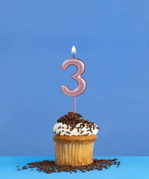 Birthday candle with cupcake on blue background - Number 3