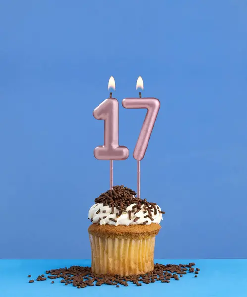 Birthday candle with cupcake on blue background - Number 17