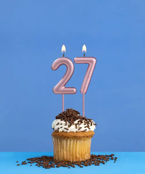 Birthday candle with cupcake on blue background - Number 27