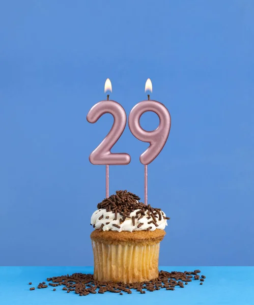 Birthday candle with cupcake on blue background - Number 29
