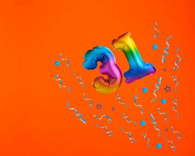 31 numaralı balonla konfeti patlaması turuncu arka planda kutlama. Doğum günü kartı