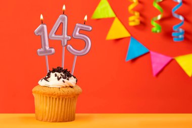 145 numaralı mumlu doğum günü keki kiraz çiçekli parlak turuncu arka plan.