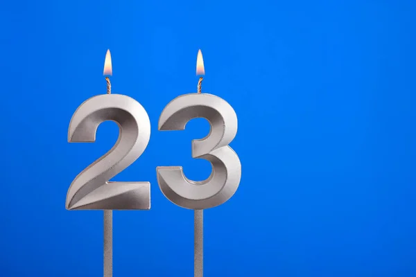 Birthday candle number 23 - Celebration card on blue background