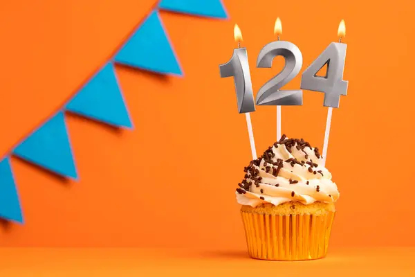 Birthday cupcake with candle number 124 - Orange background