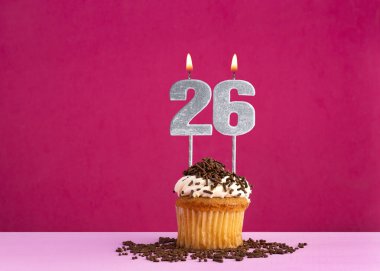 26 numaralı mumla doğum günü kutlaması - Pembe arka planda çikolatalı kek