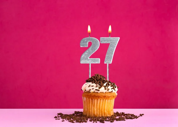 Stock image Birthday cupcake with candle number 27 - Birthday card on pink background