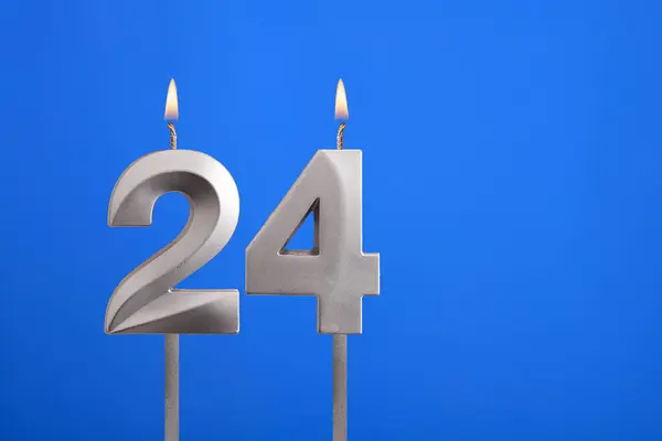 Birthday number 24 - Candle lit on blue background
