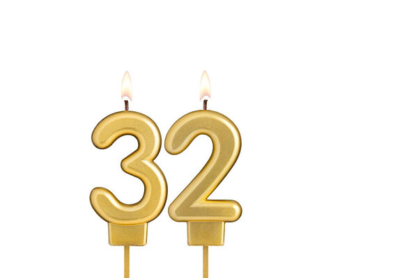 Golden number 32 birthday candle on white background