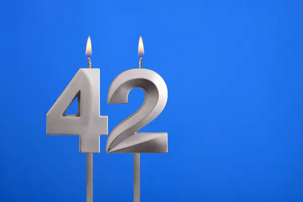 Birthday number 42 - Candle lit on blue background