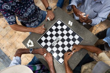 Parktaki masada domino oynayan Kolombiyalı yaşlılar