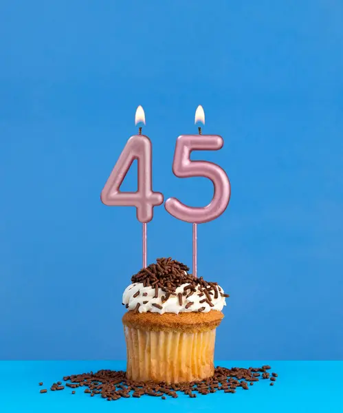 Birthday candle with cupcake on blue background - Number 45