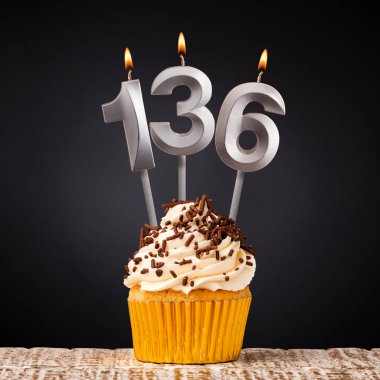 136 numaralı mumlu doğum günü pastası - Karanlık arka planda kutlama