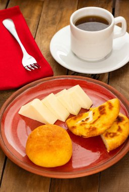 Arepa, almojabana, cheese and hot aguapanela - Typical Colombian breakfast clipart