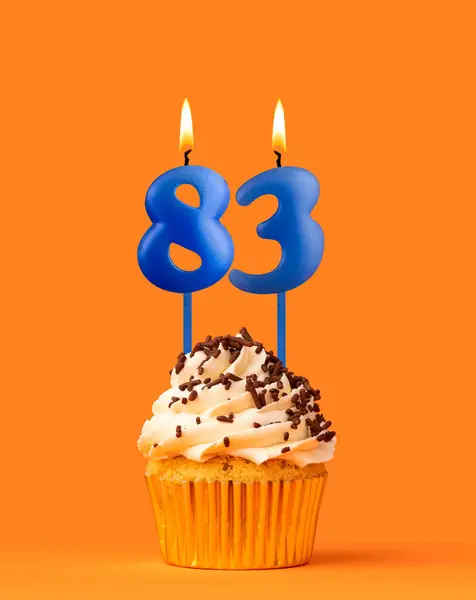 stock image Blue candle number 83 - Birthday cupcake on orange background