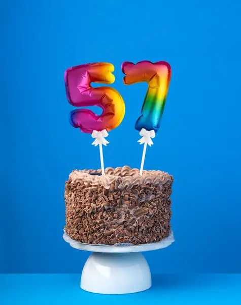エアバルーン番号57 ブルーバックグラウンドの誕生日ケーキ ロイヤリティフリーのストック画像