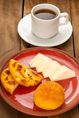 Traditional Boyaca breakfast - Arepa, almojabana, cheese and hot aguapanela clipart
