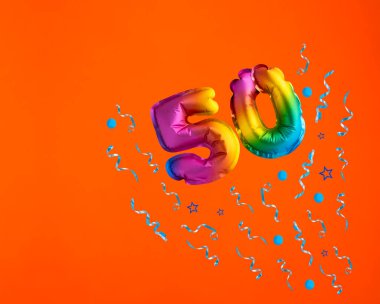 50 numaralı çok renkli balon turuncu arka planda konfeti patlaması. Doğum günü kartı