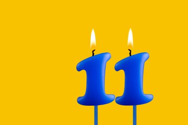 Sarı arkaplanda mavi doğum günü mumu - 11 numara